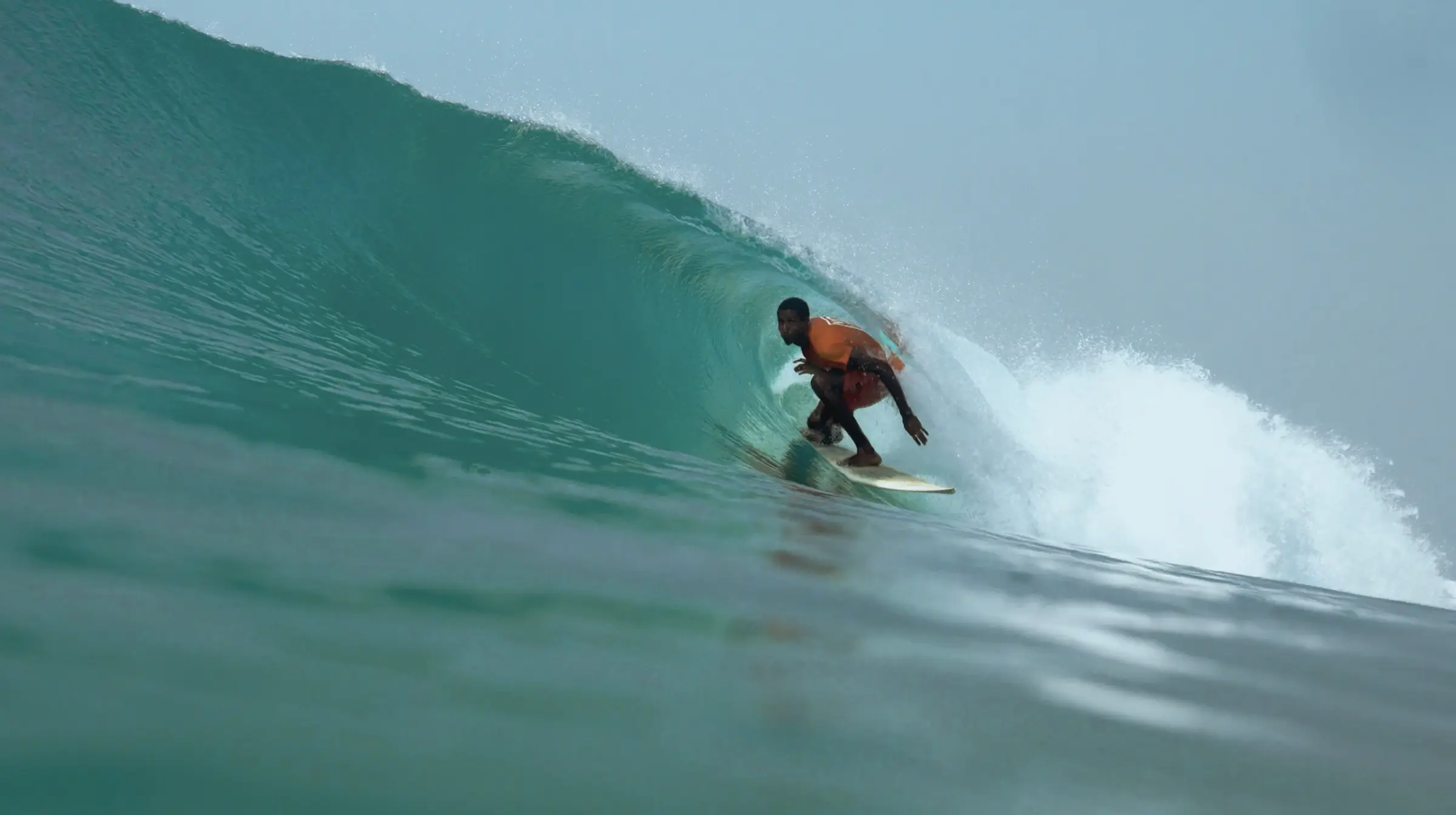 Souleymane Sidibé in the barrel of a turquoise wave.