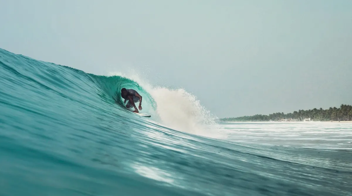 A surfer deep inside a green barrel.