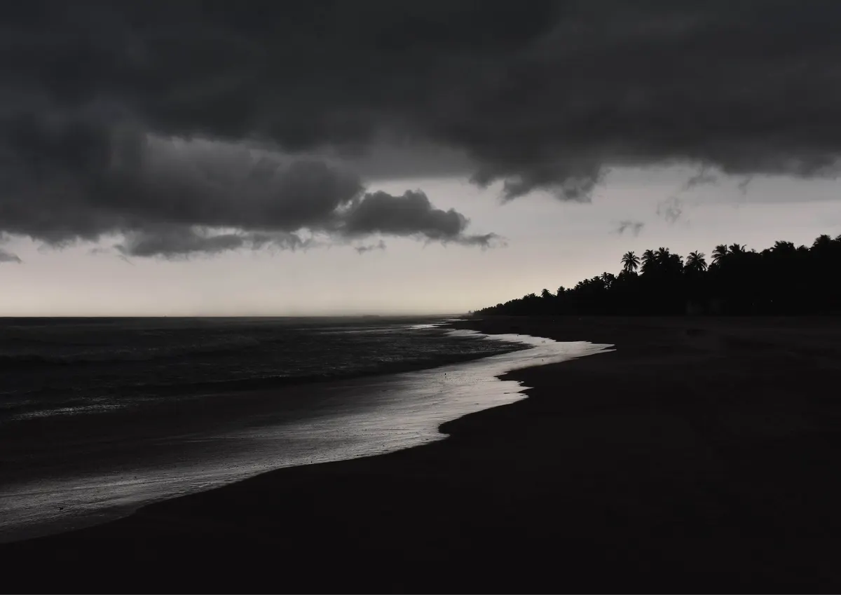 Storm clouds over the empty beach at dusk.